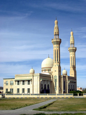 A mosque is shown, a large building with one large dome and two smaller domes and two towers, called minarets.
