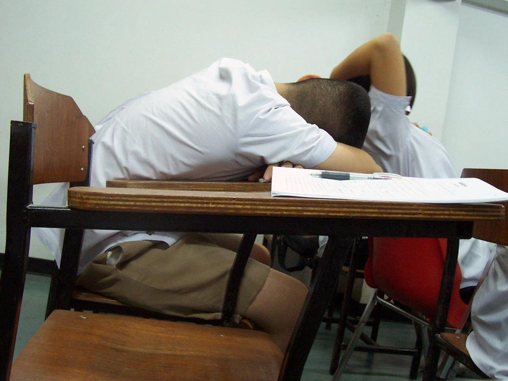 A child asleep at his desk is shown here.